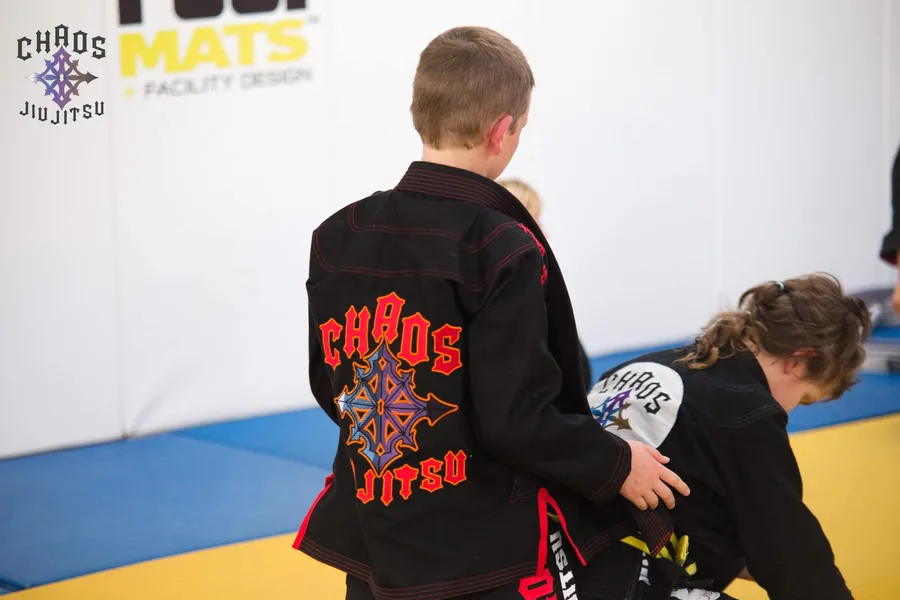 Custom black Chaos Jiu Jitsu BJJ Gi by Gimakx with full-back embroidered academy logo in red and purple